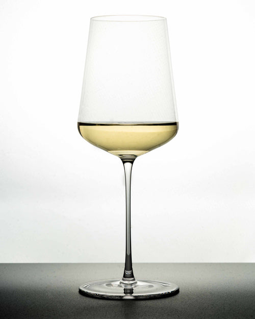 "The Mistress" white Wine Glass in white background and black - Luxury, premium and silent excellence design for wine lovers with poured white wine in it. 