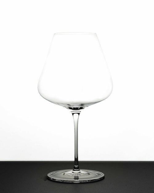 "The Mistress" red Wine Glass in white background and black - Luxury, premium and silent excellence design for wine lovers. It has tapered big bowl for aromatic wine experience. The glass is empty and shows its profile!